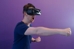 a man in a blue shirt is using a virtual reality device