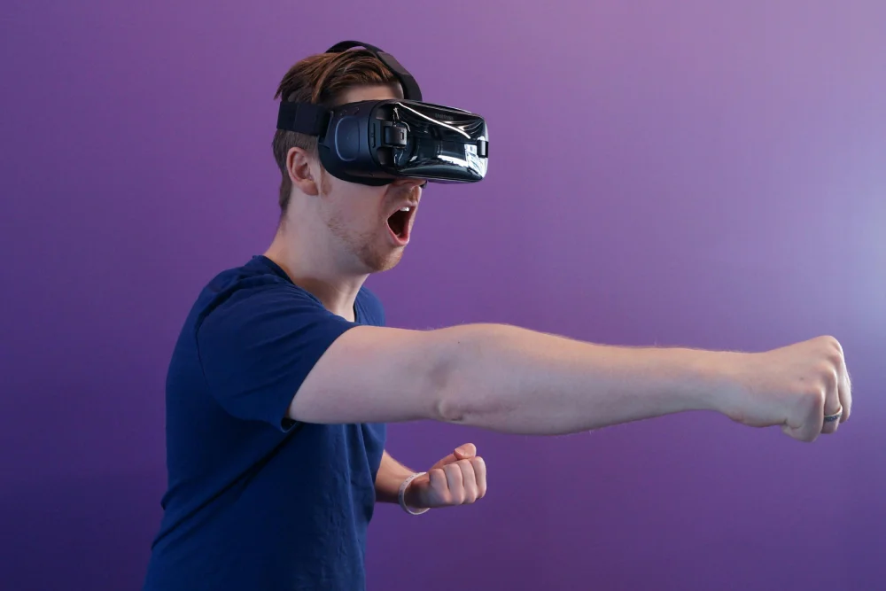 a man in a blue shirt is using a virtual reality device